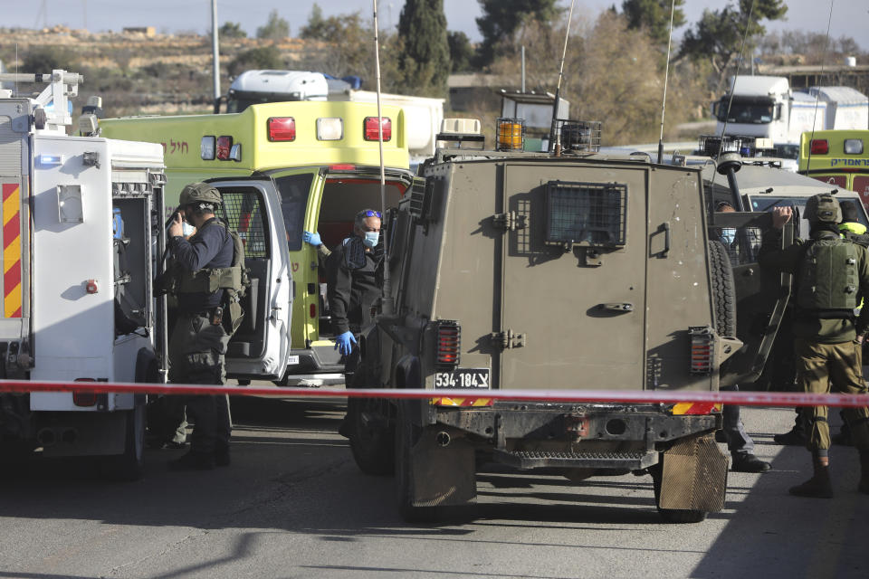 Israeli soldiers stand at the scene of an attack near the West Bank settlement of Gush Etzion, Sunday, Jan. 31, 2021. An Israeli soldier on Sunday shot and killed a Palestinian suspected of attempting an attack at a West Bank junction south of Bethlehem, the military said. (AP Photo/Mahmoud Illean)