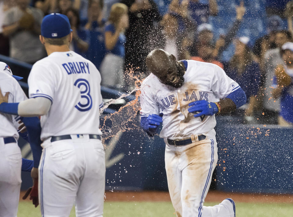 Toronto Blue Jays' Anthony Alford gets a sports drink shower as he arrives at home plate after hitting a walk-off home run to end the ballgame in the 15th inning against the Baltimore Orioles, Monday, Sept. 23, 2019, in Toronto. Toronto won 11-10. (Fred Thornhill/The Canadian Press via AP)