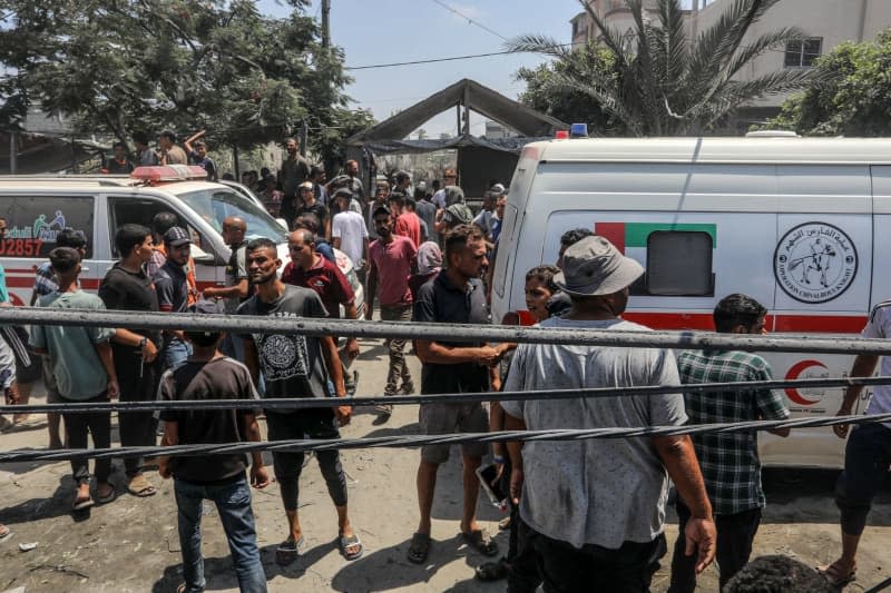 Palestinians inspect the damage next to ambulance vehicles after an Israeli air strike on the Al-Mawasi camp for the displaced Palestinians. Abed Rahim Khatib/dpa