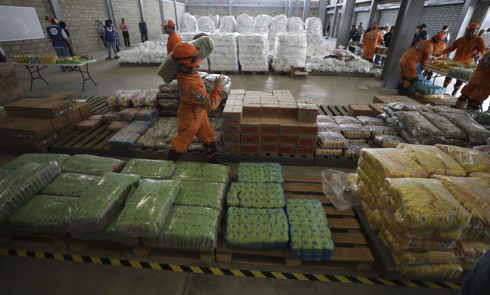 Voluntarios y bomberos colombianos preparan la ayuda entregada por Estados Unidos cerca del puente Las Tienditas cerca de Cúcuta, Colombia. (Foto: AP/Fernando Vergara)