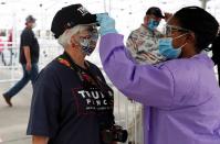 A supporter wearing a face mask has her temperature checked outside the venue for U.S. President Donald Trump's rally in Tulsa