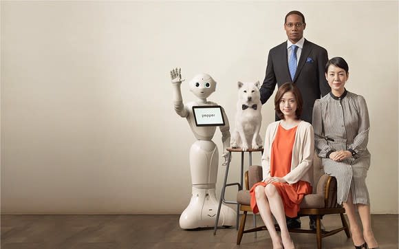 Softbank's iconic Pepper robot standing with people and a dog