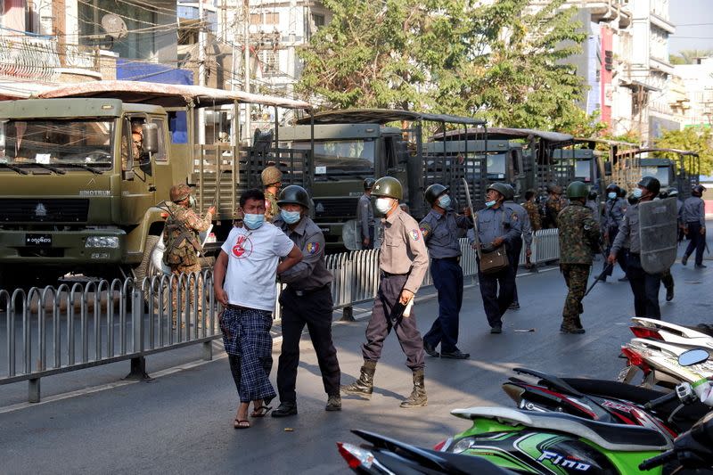Police detains a man during a protest against the military coup in Mandalay