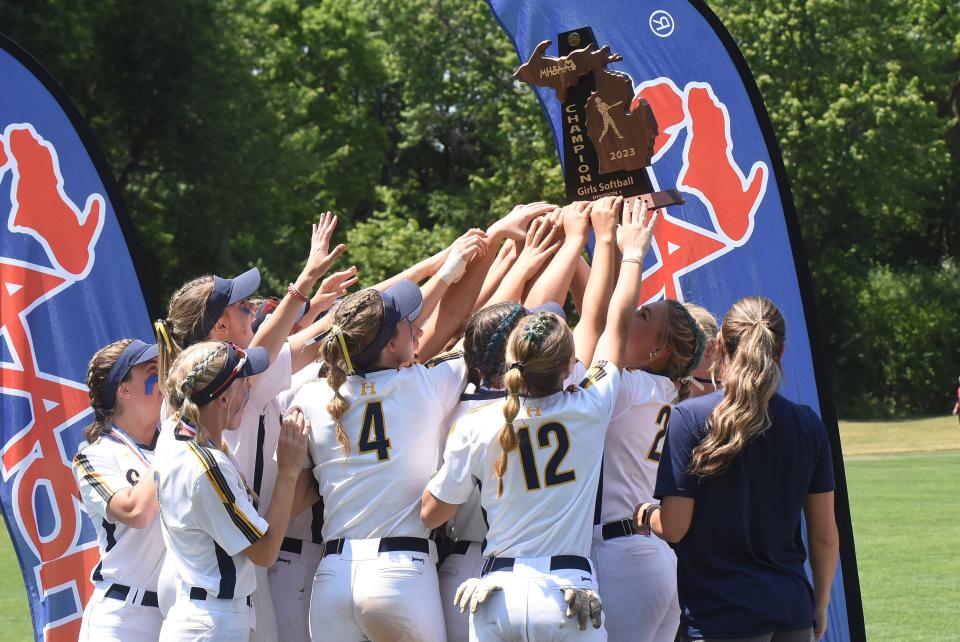 Hartland softball players hoist the state championship trophy, the school's eighth since 2015, Saturday, June 17, 2023 at Michigan State University.