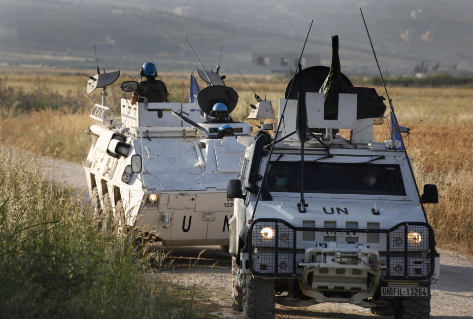 U.N peacekeepers patrol at the area where Hezbollah supporters hold a protest in solidarity with Palestinians amid an escalating Israeli military campaign in Gaza, on the Lebanese-Israeli border in front of the Israeli settlement of Metula, background, near the southern village of Kafr Kila, Lebanon, Friday, May 14, 2021. (AP Photo/Mohammed Zaatari)