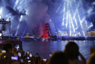 People watch a brig with scarlet sails makes its way through Dvortsovy (Palace) drawbridge on the Neva River during the Scarlet Sails festivities marking school graduation in St. Petersburg, Russia, early Saturday, June 25, 2022. The Scarlet Sails celebration is a rite of passage both figuratively and literally. Every year, tall ships with glowing red sails make their way down the Neva River in St. Petersburg to honor recent school graduates as they set out on the journey into adulthood. (AP Photo/Elena Ignatyeva)