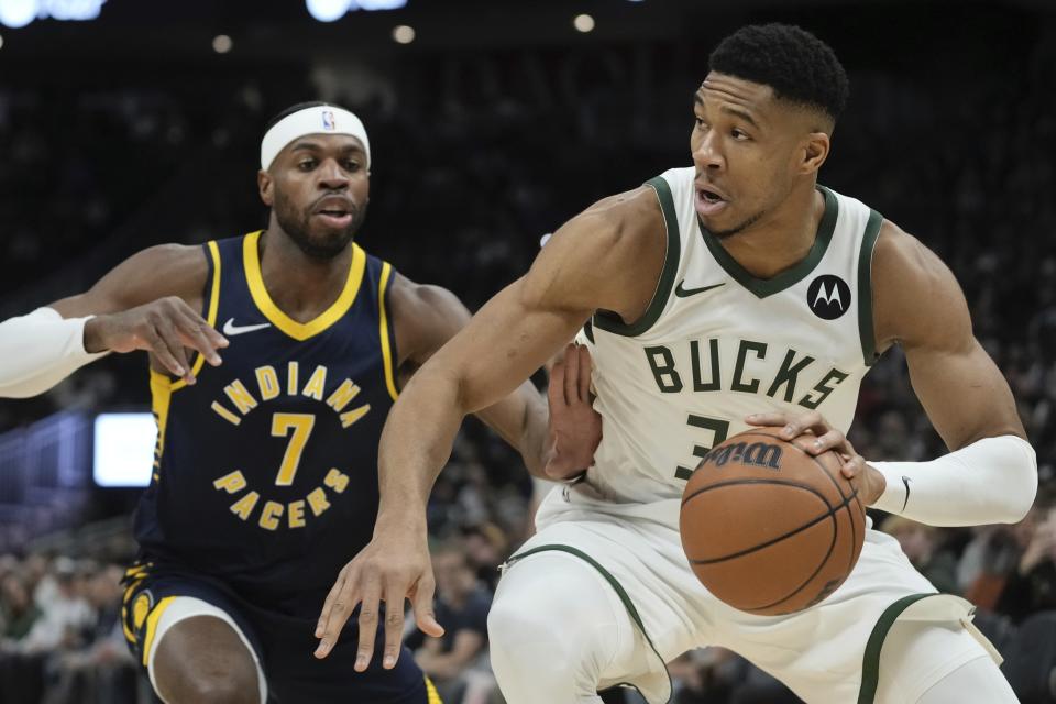 Milwaukee Bucks' Giannis Antetokounmpo drives past Indiana Pacers' Buddy Hield during the first half of an NBA basketball game Wednesday, Dec. 13, 2023, in Milwaukee. (AP Photo/Morry Gash)