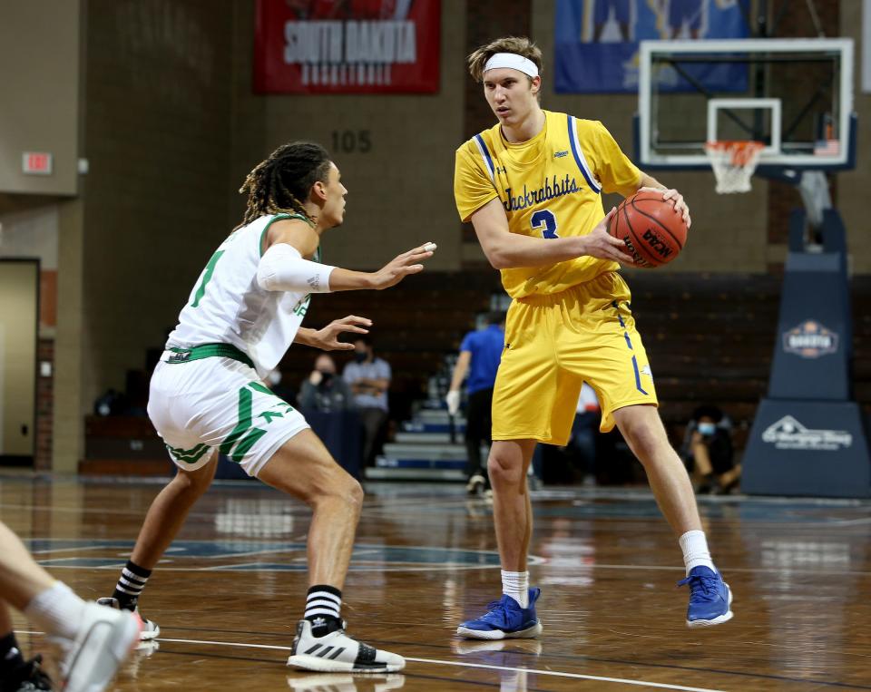 Baylor Scheierman #3 of the South Dakota State Jackrabbits looks to make a move past Seybian Sims #1 of the North Dakota Fighting Hawks during the CU Mortgage Direct Dakota Showcase at the Sanford Pentagon on December 11, 2020 in Sioux Falls, South Dakota.