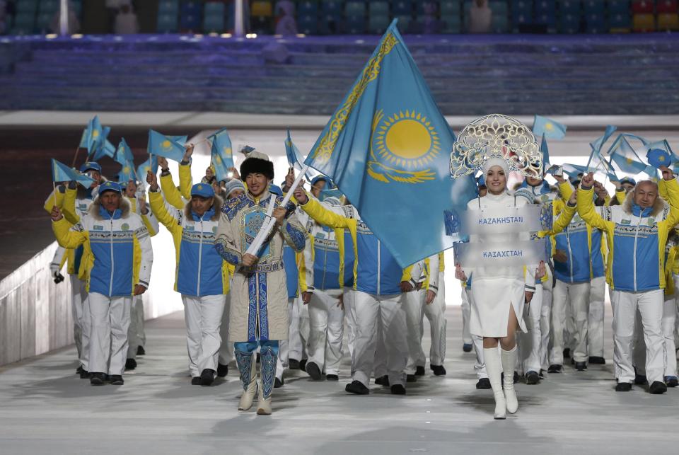 Kazakhstan's flag-bearer Yerdos Akhmadiyev leads his country's contingent during the opening ceremony of the 2014 Sochi Winter Olympics, February 7, 2014. REUTERS/Phil Noble (RUSSIA - Tags: OLYMPICS SPORT)