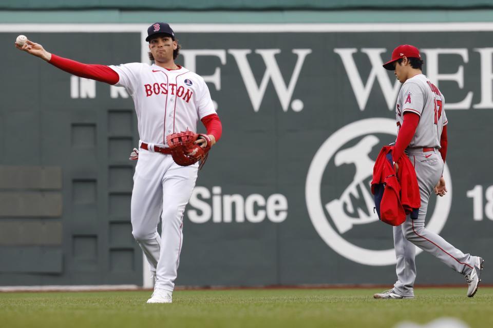 Boston Red Sox's Triston Casas warms up as Los Angeles Angels' Shohei Ohtani (17) walks in from the bull pen before a baseball game, Monday, April 17, 2023, in Boston. (AP Photo/Michael Dwyer)