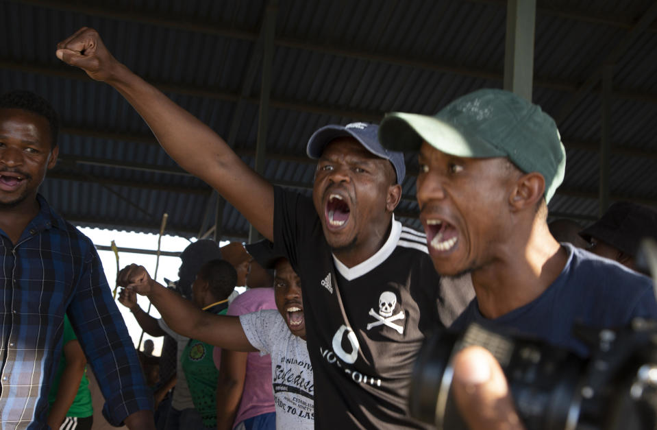 Miners gather at the top of a goldmine shaft in Springs, South Africa, Tuesday, Oct. 24, 2023. Police in South Africa say a group of gold miners from an unregistered, rival union are holding hundreds of colleagues underground for the second day over a union dispute. (AP Photo/Denis Farrell)