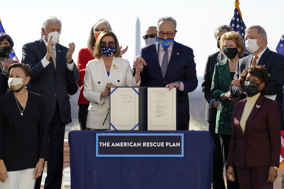 FILE - House Speaker Nancy Pelosi of Calif., and Senate Majority Leader Chuck Schumer of N.Y., poses after signing the $1.9 trillion COVID-19 relief bill during an enrollment ceremony on Capitol Hill, March 10, 2021, in Washington. Federal officials estimate that local governments now have spending plans in place for most of the money they received under a prominent pandemic relief law. In some cases, it's hard to know exactly how the money is being used, because some governments haven't supplied details about their projects. (AP Photo/Alex Brandon, File)