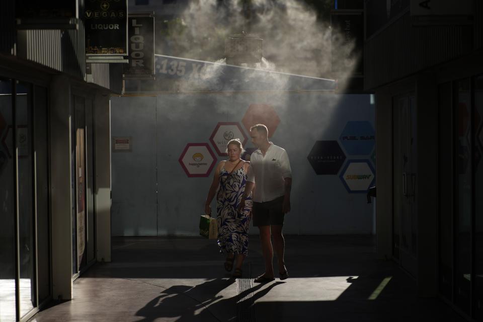 FILE - People walk through cooling misters along the Las Vegas Strip, July 13, 2023, in Las Vegas. A new study Tuesday, July 25, finds these intense and deadly hot spells gripping much of the globe in the American Southwest and Southern Europe could not have occurred without climate change. (AP Photo/John Locher, File)