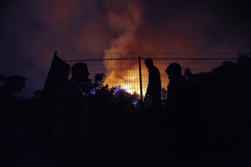 People watch as a forest fire rages towards urban areas in the city of Valparaiso, Chile, Sunday, April 13, 2014. Authorities say the first fire has destroyed at least 150 homes and is forcing evacuations. ( AP Photo/ Luis Hidalgo)