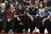 Colin Kaepernick, center left, sits beside Akim Aliu as they watch the Toronto Raptors take on the Boston Celtics in an NBA basketball game in Toronto, Monday, Dec. 5, 2022. (Chris Young/The Canadian Press via AP)