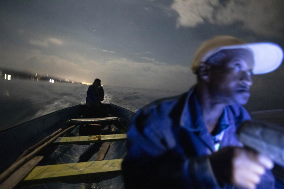 White River Fish Sanctuary wardens Mark Lobban, left, and Donald Anderson patrol the no-take zone for illegal fishermen under moonlight in Ocho Rios, Jamaica, Saturday, Feb. 16, 2019. Two years ago, fishermen joined with local businesses to form a marine association and negotiate the boundaries for a no-fishing zone stretching two miles along the coast. A simple line in the water is hardly a deterrent, however, for a boundary to be meaningful, it must be enforced. (AP Photo/David Goldman)