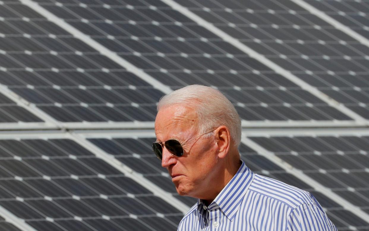 Joe Biden walks past solar panels in Plymouth, New Hampshire, in 2019 - BRIAN SNYDER /REUTERS