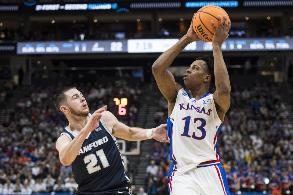Kansas guard Elmarko Jackson (13) controls the ball while guarded by Samford guard Rylan Jones (21) during the first half of a first-round college basketball game in the NCAA Tournament in Salt Lake City, Thursday, March 21, 2024. (AP Photo/Isaac Hale)