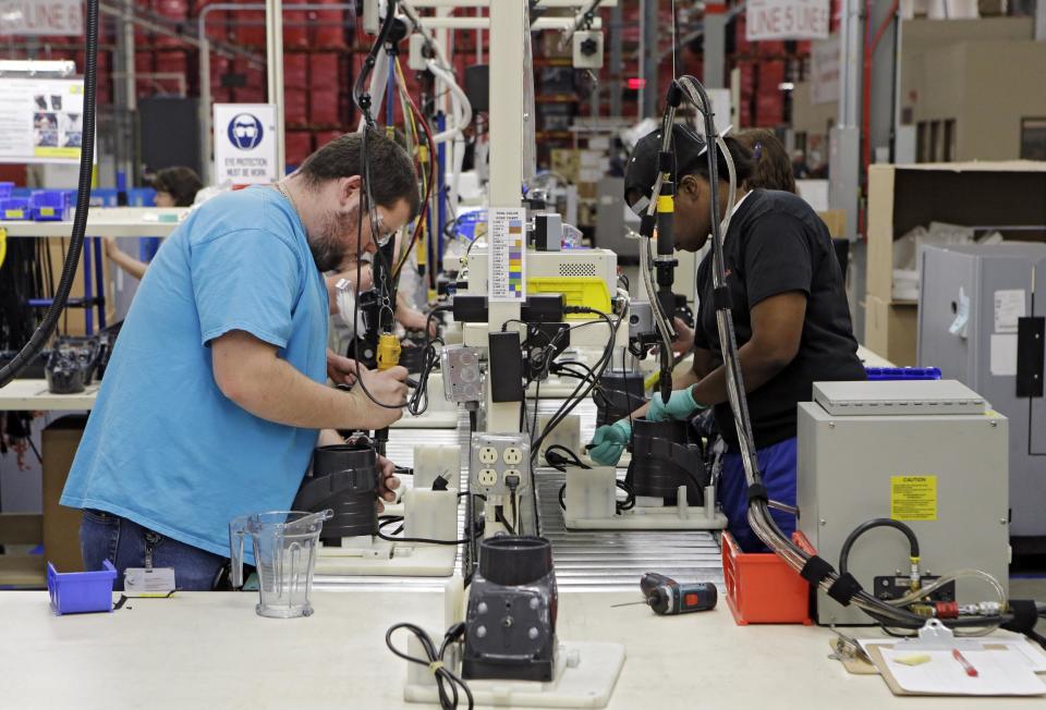 In this April 15, 2014 photo, workers assemble blender bases at the Vitamix manufacturing facility in Strongsville, Ohio. The Institute for Supply Management, a trade group of purchasing managers, issues its index of manufacturing activity for April on Thursday, May 1, 2014. (AP Photo/Mark Duncan)