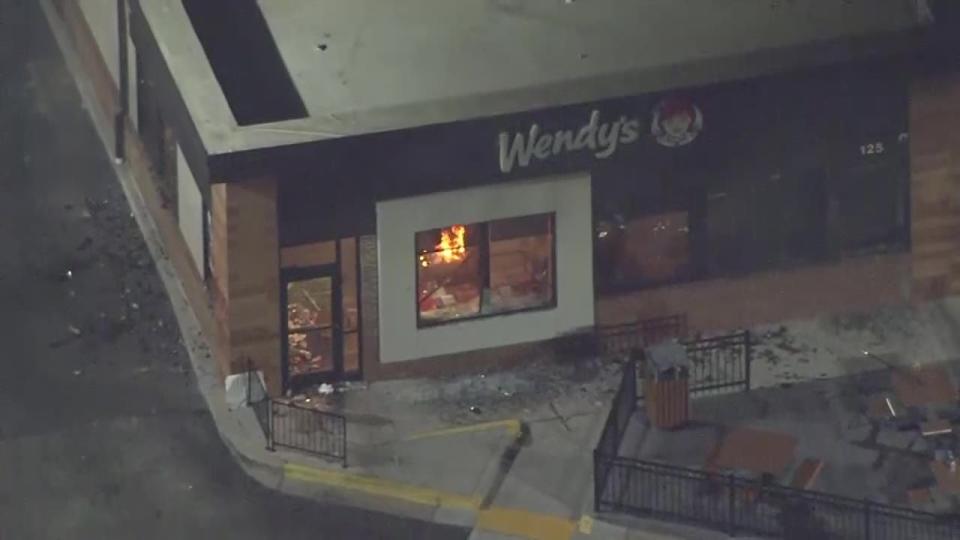 Protesters break glass and set a Wendy's on fire after deadly police shooting