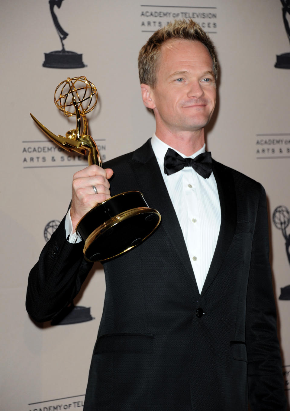 Neil Patrick Harris poses backstage with his award for outstanding special class programs for the "66th Annual Tony Awards" at the Primetime Creative Arts Emmy Awards at the Nokia Theatre L.A. Live on Sunday, Sept. 15, 2013, in Los Angeles. (Photo by Richard Shotwell/Invision/AP)