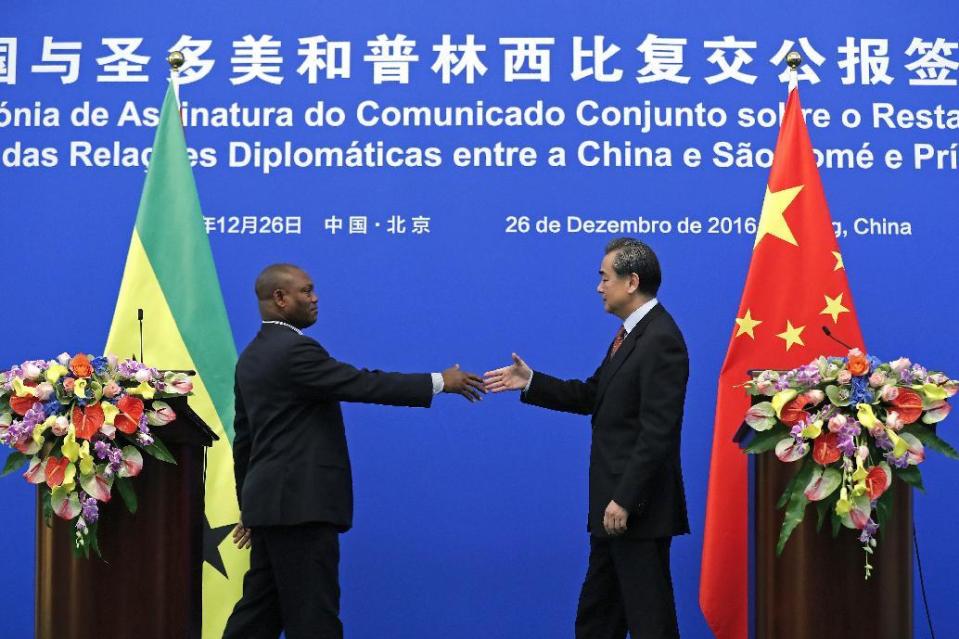 In this Monday, Dec. 26, 2016 photo, Chinese Foreign Minister Wang Yi, right, prepares to shake hands with his Sao Tome counterpart Urbino Botelho after a joint press statement at the Diaoyutai State Guesthouse in Beijing. China and Sao Tome and Principe officially resumed diplomatic relations on Monday, in a triumph for Beijing over rival Taiwan after the African island nation abruptly broke away from the self-ruled island last week. (AP Photo/Andy Wong, File)