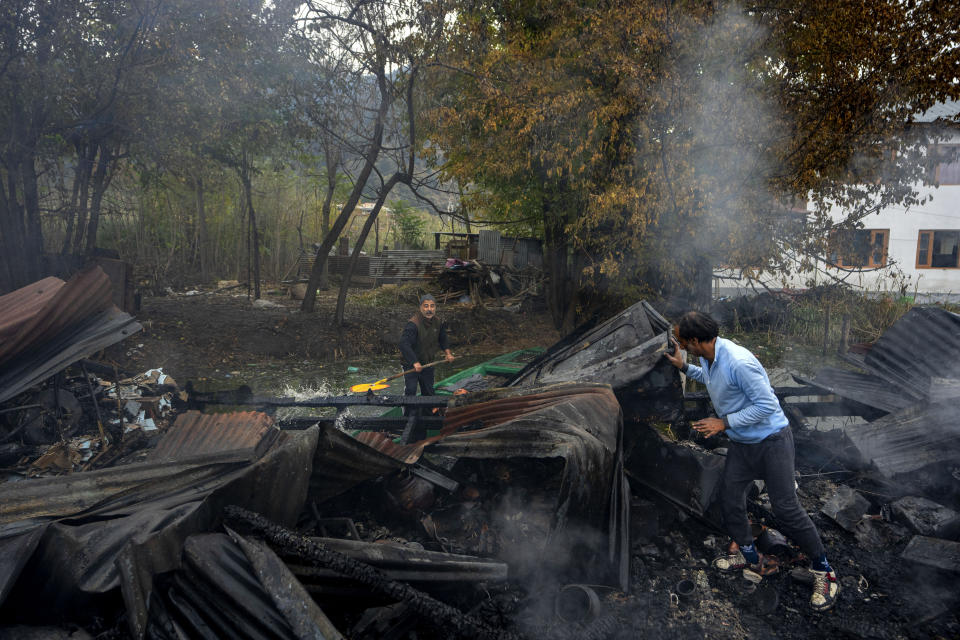 Kashmiris search for salvageable items after a fire gutted several houseboats early morning in the interiors of Dal Lake, on the outskirts of Srinagar, Indian controlled Kashmir, Saturday, Nov. 11, 2023. A massive fire engulfed some wooden houseboats on Saturday and three charred bodies were recovered from the wreckage, officials said. (AP Photo/Dar Yasin)