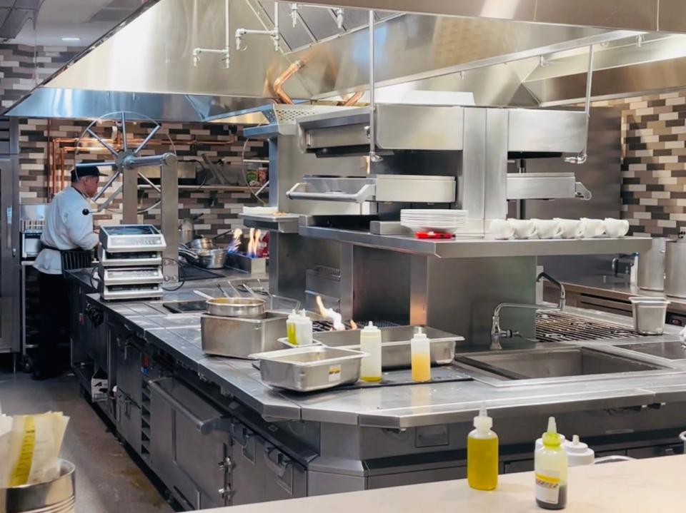 View of restaurant kitchen with chef working at Topolino’s Terrace