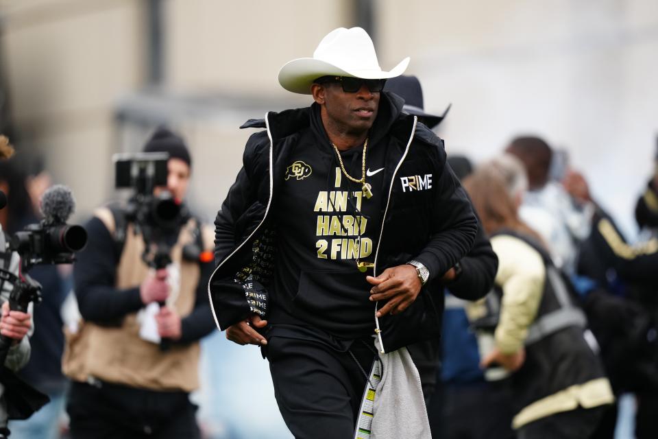 Deion Sanders hits the field before the start of the spring game in April.