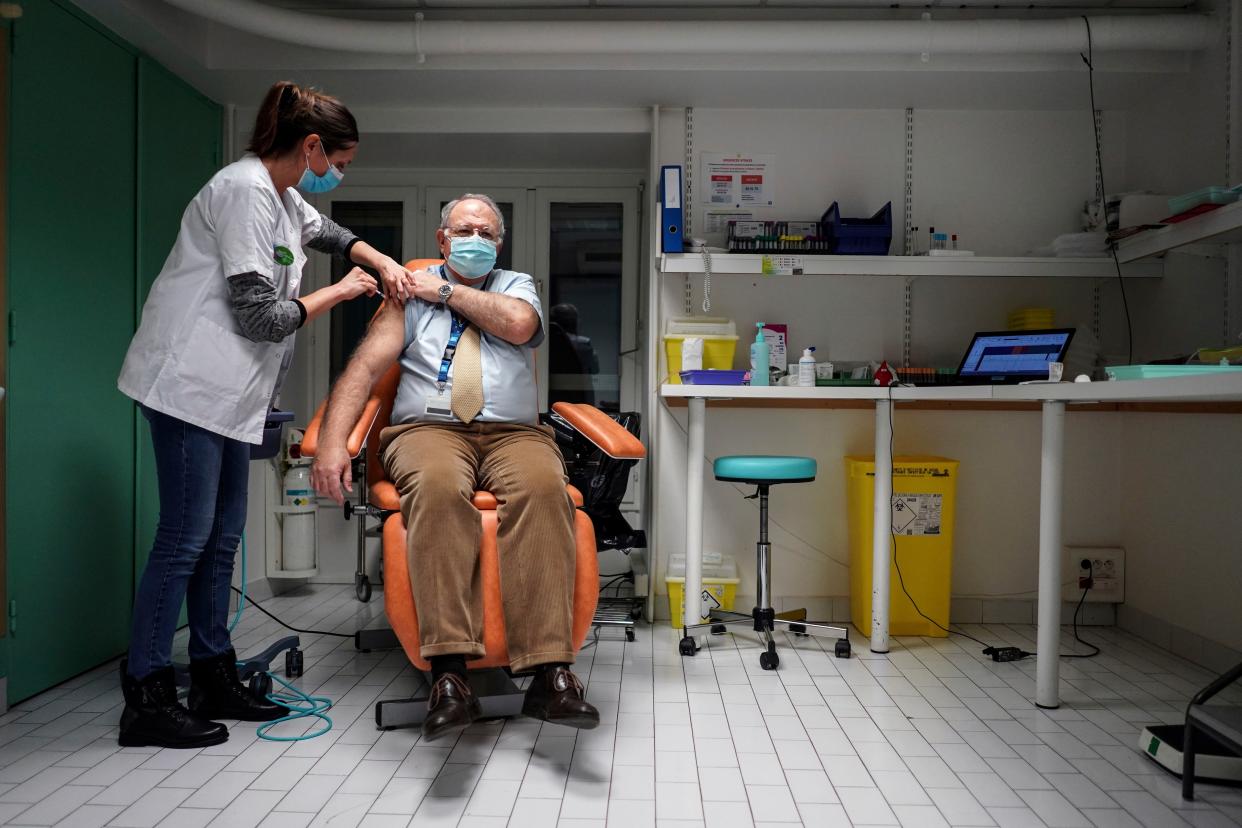 Dr. Christian Chidiac gets a Pfizer-BioNTech COVID-19 vaccine in La Croix-Rousse hospital, in Lyon, central France, Wednesday, Jan. 6, 2021. Amid public outcry, France's health minister promised Tuesday an "exponential" acceleration of his country's shockingly slow coronavirus vaccination process.