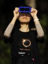 PALM COVE, AUSTRALIA - NOVEMBER 14: A spectator views the solar eclipse through special eclipse viewing glasses on November 14, 2012 in Palm Cove, Australia. Thousands of eclipse-watchers have gathered in part of North Queensland to enjoy the solar eclipse, the first in Australia in a decade. (Photo by Ian Hitchcock/Getty Images)