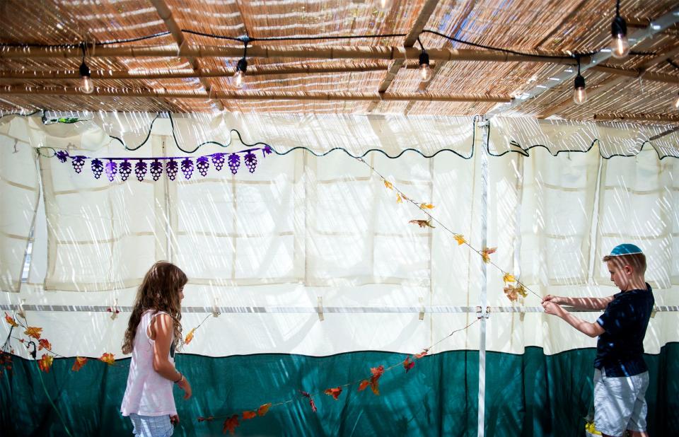 Palm Beach Synagogue Hebrew school students Aerin Bar-Or, 7, and Noah Fromowitz, 9, decorate the Sukkah, an outdoor structure, for Sukkot Sept. 19, 2021 in Palm Beach.  The Pensacola community is invited to a similar unity event on Oct. 13 that will feature live music, a BBQ and bar, entertainment, and a children's program.