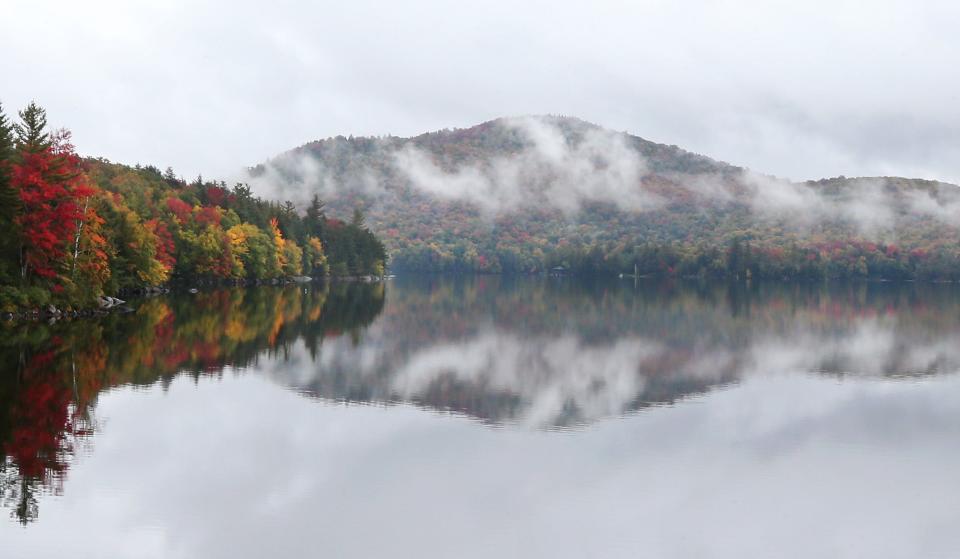 Fall colors are shrouded in the morning mist on Tupper Lake in the Adirondacks.  