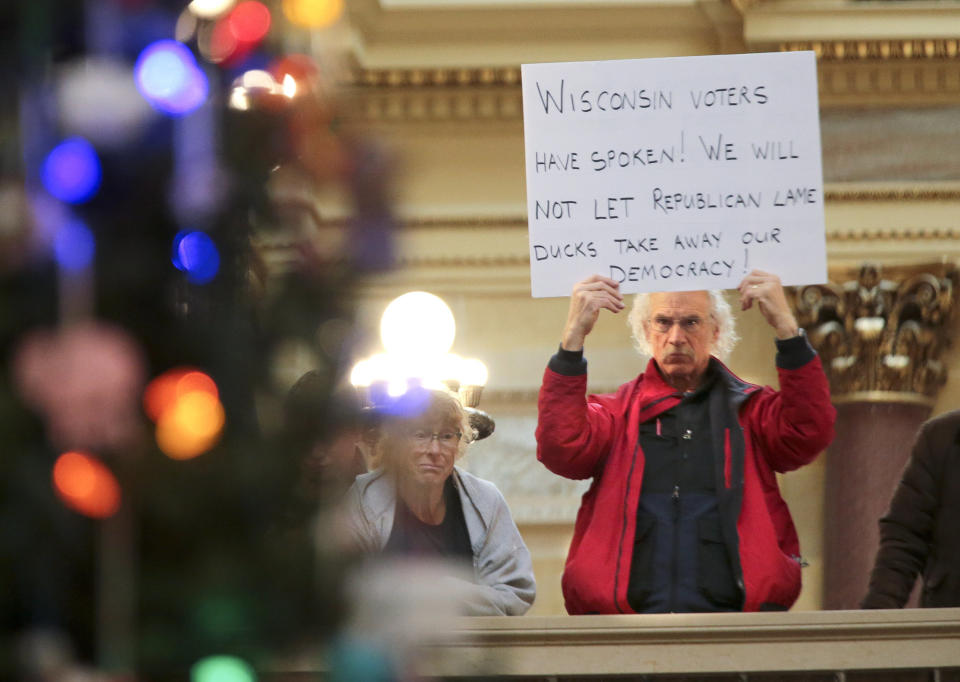 A protestor holds a sign as Wisconsin Republicans strip the incoming Democratic governor of power during the 2018 lame duck session. (Photo: ASSOCIATED PRESS)