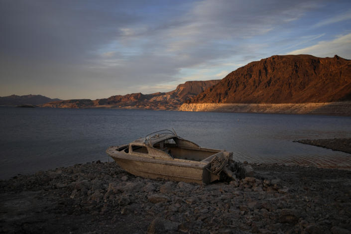 FILE - A formerly sunken boat sits high and dry along the shoreline of Lake Mead at the Lake Mead National Recreation Area, Tuesday, May 10, 2022, near Boulder City, Nev. Las Vegas area water officials want to cap the size of new swimming pools, citing worries about supplies from the drying-up Lake Mead reservoir on the drought-stricken Colorado River. (AP Photo/John Locher, File)