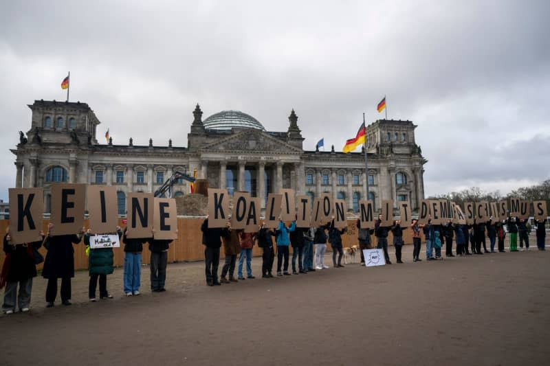 People hold placards with the slogan "No coalition with fascism" during the demonstration of an alliance "We are the firewall" for democracy and against right-wing extremism. Christophe Gateau/dpa