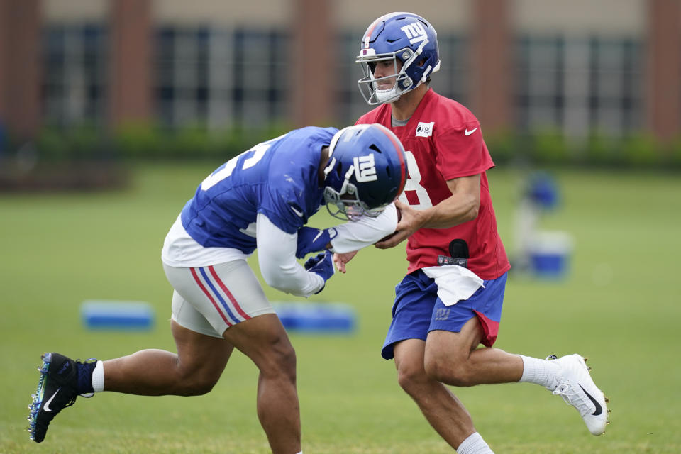 New York Giants quarterback Daniel Jones, right, fakes a handoff to Saquon Barkley during the NFL football team's training camp in East Rutherford, N.J., Wednesday, Aug. 19, 2020. (AP Photo/Seth Wenig)