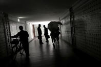 <p>Women carry parasols while two men stop to chat as they walk through an underpass in downtown Pyongyang on June 16, 2017, in North Korea. (Photo: Wong Maye-E/AP) </p>