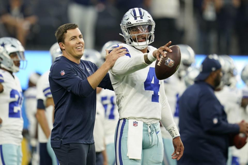 Dallas Cowboys quarterback Dak Prescott (4) warms up with offensive coordinator Kellen Moore.