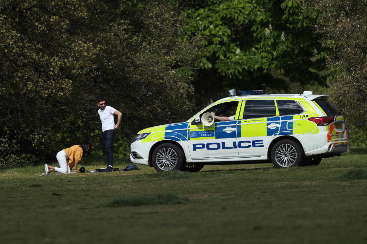 Police officers in a patrol car move on sunbathers in Greenwich Park, London, as the UK continues in lockdown to help curb the spread of the coronavirus.