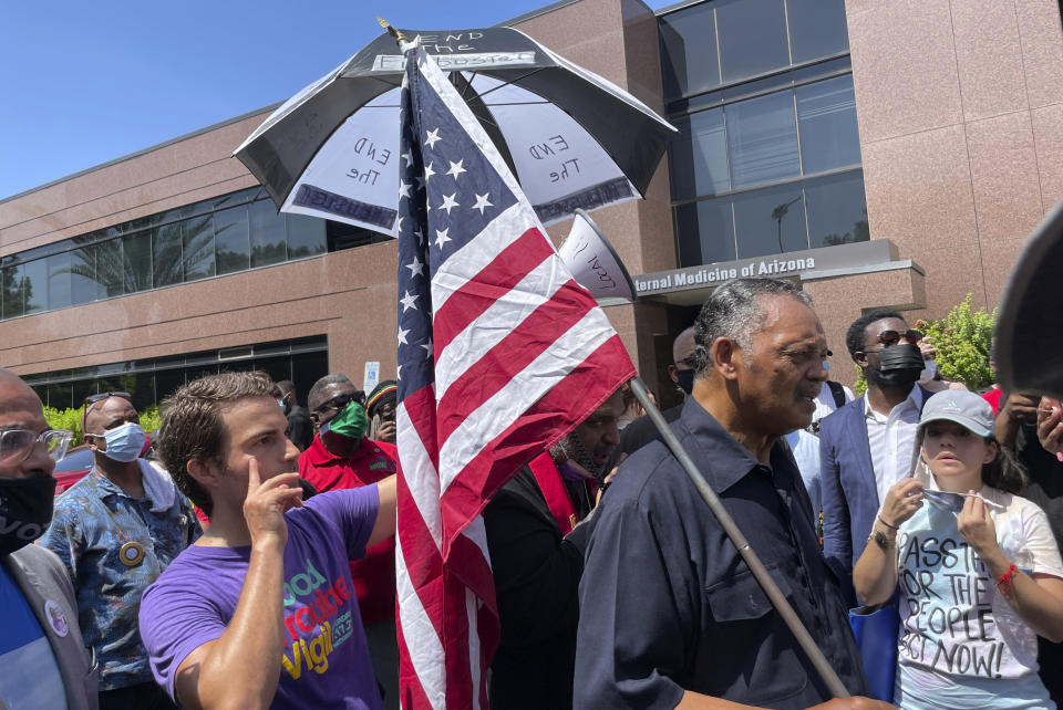 The Rev. Jesse Jackson leads protesters outside the office of U.S. Sen. Kyrsten Sinema, D-Arizona, on Monday, July 26, 2021, in Phoenix. Jackson was among 35 people arrested for refusing to leave Sinema's office while protesting her opposition to ending the filibuster to pass voting rights legislation. (AP Photo/Jonathan J. Cooper)