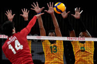 Brazil players b lock a shot bye Japan's Yuki Ishikawa during the men's volleyball quarterfinal match between Japan and Brazil at the 2020 Summer Olympics, Tuesday, Aug. 3, 2021, in Tokyo, Japan. (AP Photo/Frank Augstein)