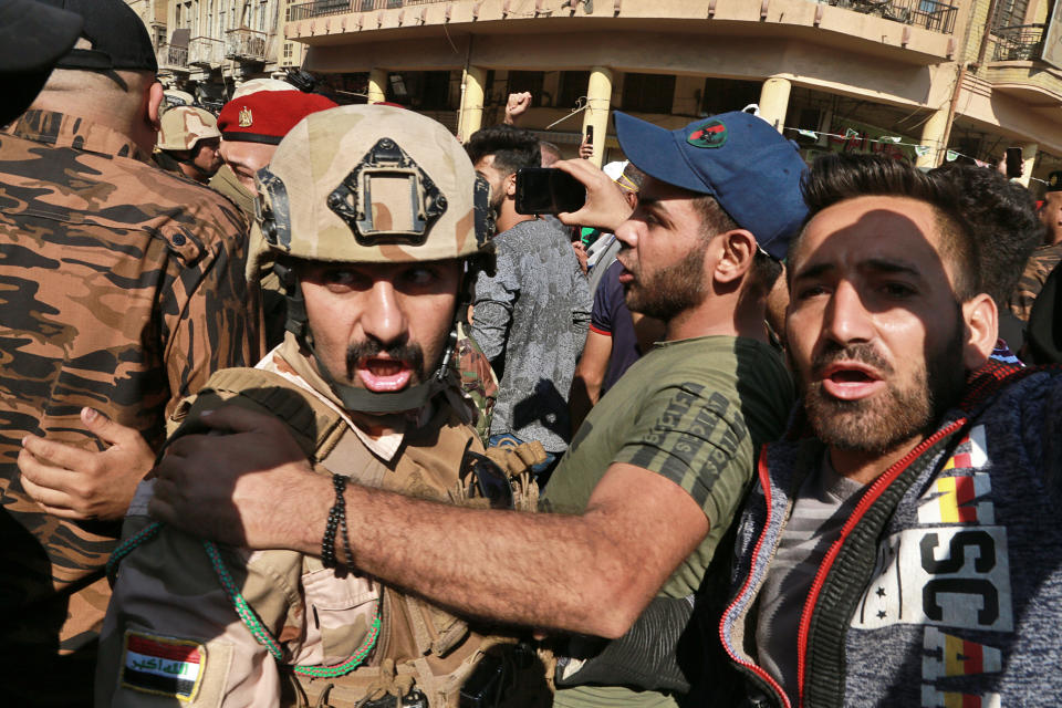 Army soldiers try to prevent anti-government protesters from crossing the al- Shuhada (Martyrs) bridge in central Baghdad, Iraq, Wednesday, Nov. 6, 2019. Tens of thousands of people have taken to the streets in recent weeks in the capital, Baghdad, and across the Shiite south, demanding sweeping political change. (AP Photo/Hadi Mizban)