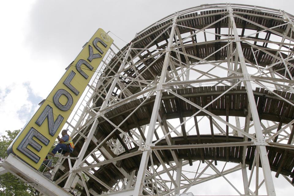 In a Tuesday, June 26, 2012 photo made at Coney Island in New York,  a maintenance worker inspects the Cyclone roller coaster sign.  The New York City landmark and international amusement icon will be feted Saturday, June 30 with a birthday party in its honor.  (AP Photo/Mary Altaffer)