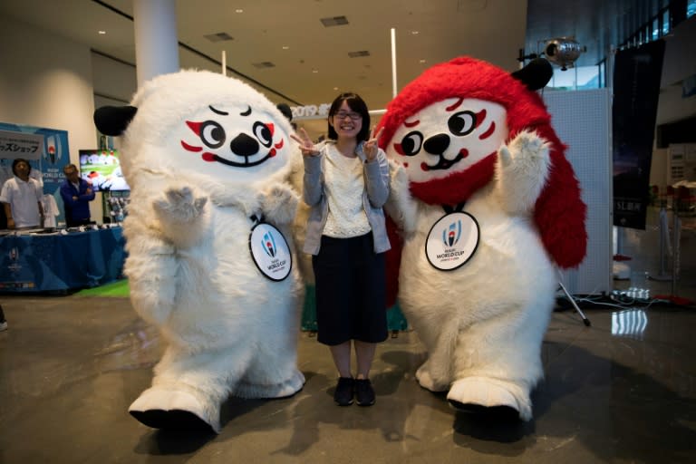 A Japanese woman poses with Rugby World Cup 2019 mascots, Ren (L) and G (R) at a rugby pop-up museum in Kamaishi