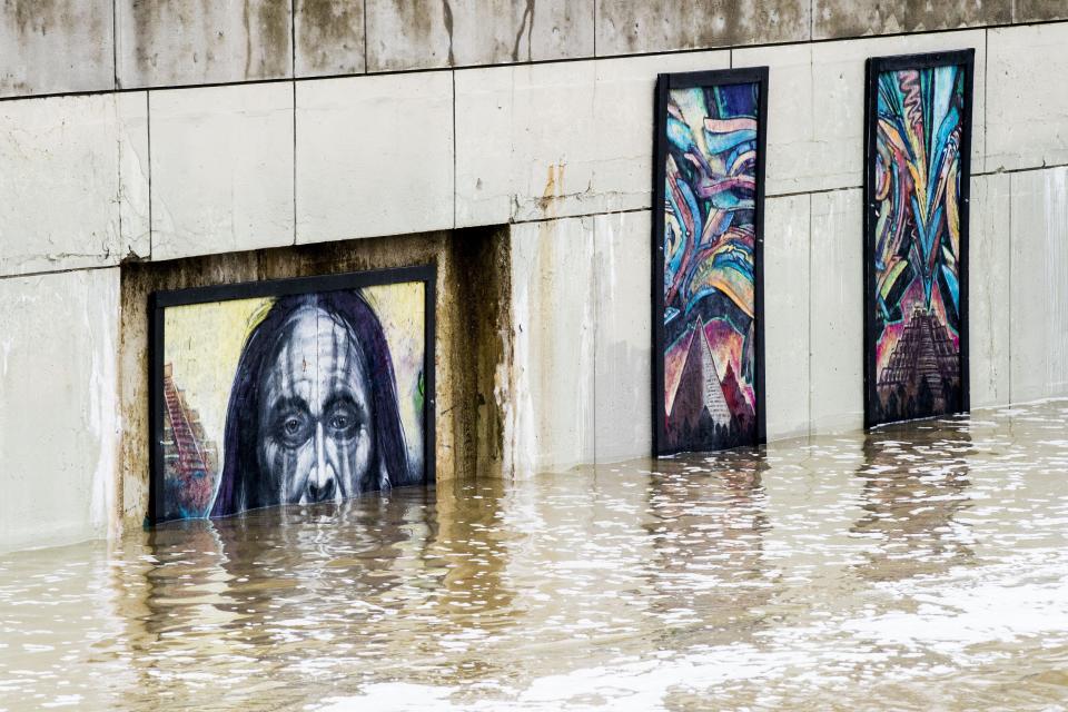 <p>The Flint River overflows onto artist renderings along what is normally a walkway as heavy rain causes flooding on Wednesday, Feb. 21, 2018 in Flint, Mich. (Photo: Jake May/The Flint Journal-MLive.com via AP) </p>