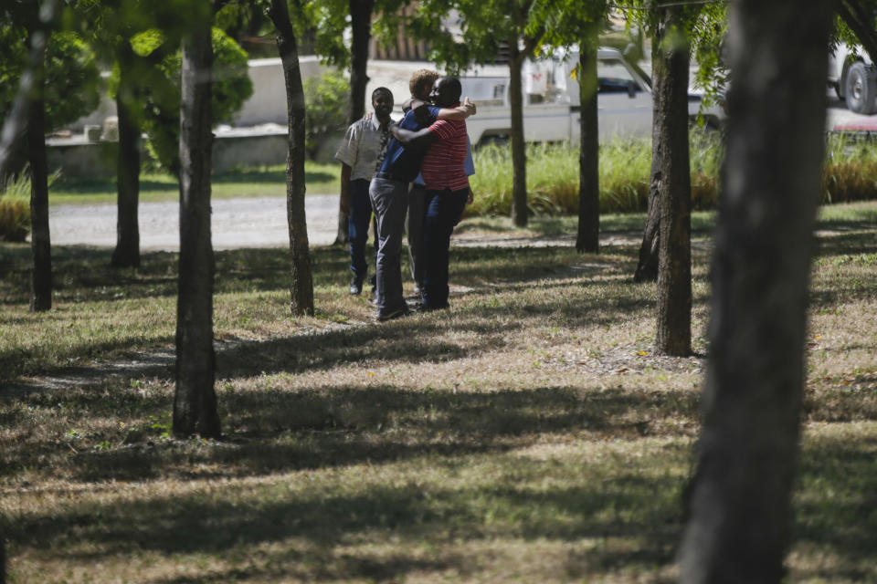 People hug at the Christian Aid Ministries headquarters in Titanyen, north of Port-au-Prince, Haiti, Thursday, Dec. 16, 2021. Twelve remaining members of a U.S.-based missionary group who were kidnapped two months ago have been freed, according to the group and Haitian police. (AP Photo/Odelyn Joseph)