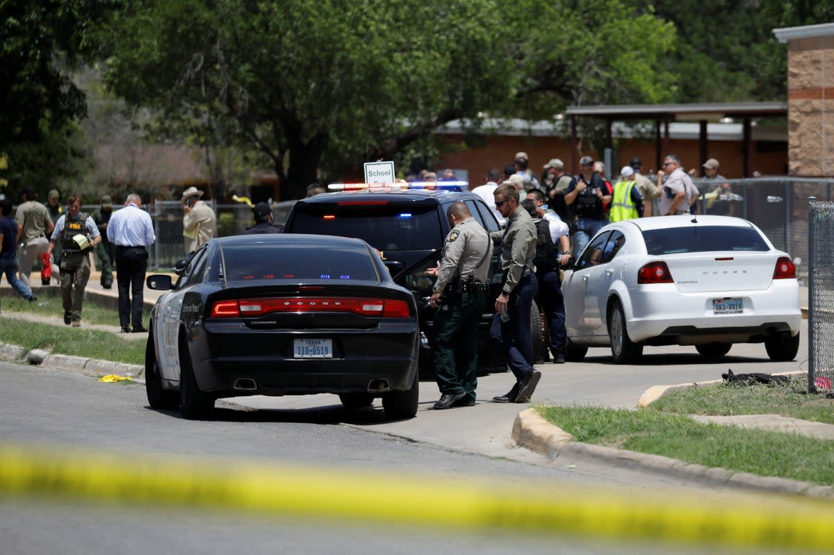 Law enforcement officers guard the scene of a shooting at Robb Elementary School in Uvalde, Texas, on May 24 (REUTERS)