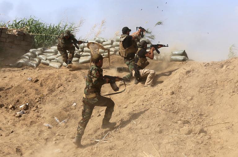 Iraqi Sunni fighters battling Islamic State (IS) group jihadists alongside government forces fire their weapons on the outskirts of Iraq's Baiji oil refinery on May 25, 2015