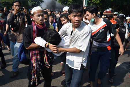 People carry an injured protester to safety during clashes with police in Jakarta, Indonesia, May 22, 2019 in this photo taken by Antara Foto. Antara Foto/Aditya Pradana Putra/ via REUTERS